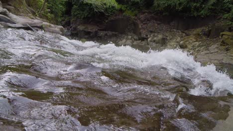 Water-gracefully-cascading-over-the-rocks-of-Goa-Rang-Reng-Waterfall,-captured-in-slow-motion