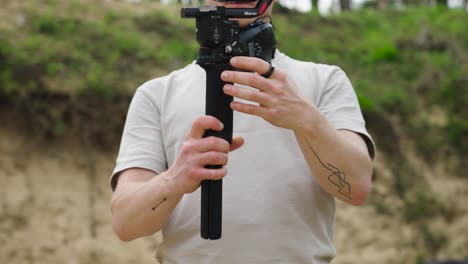 Static-shot-of-male-hold-gimbal-stabilizer-and-attach-high-capacity-battery-grip