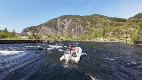 Tourists-in-narrow-Norway-fjord-with-strong-currents-at-Stamneshella-Norway,-Slow-motion-aerial-fly-over