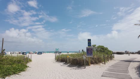 Camino-Que-Conduce-A-Miami-Beach-Con-Palmeras-Bajo-Un-Cielo-Parcialmente-Nublado