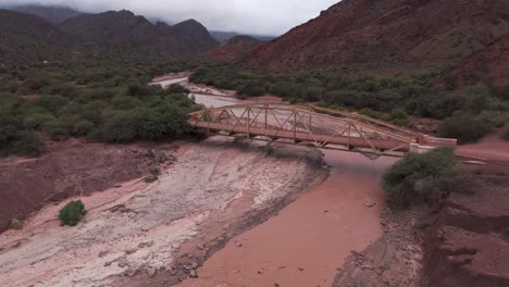 Rustic-Bridge-Over-A-Red-River-In-Route-68,-Quebrada-De-Las-Conchas,-Cafayate,-Argentina