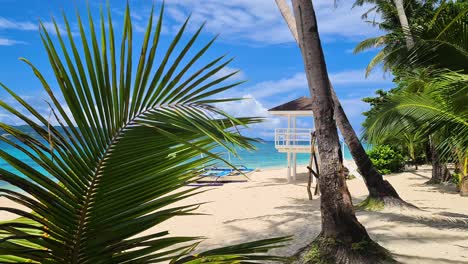 Maravilloso-Paisaje-Tropical,-Arena-Blanca,-Palmeras-Verdes,-Torre-De-Salvavidas-En-Una-Isla-Exótica