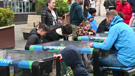 Kids-playing-on-touchscreen-tables-within-Regents-Street-to-the-UEFA-Champions-League-in-Wembley,-London,-United-Kingdom