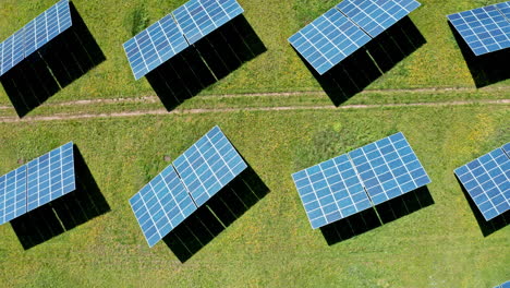 Paneles-Solares-Dispuestos-En-Filas-En-Un-Campo-Verde-Bajo-La-Luz-Del-Sol-Brillante