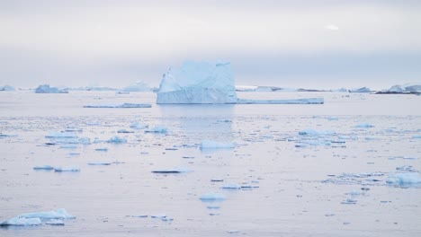 Beautiful-Iceberg-at-Sunset-in-Antarctica,-Big-Large-Massive-Icebergs-with-Amazing-Shapes-and-Ice-Formation,-Sunrise-Seascape-with-Orange-Sky-in-Winter-Landscape-Scenery-on-Antarctic-Peninsula