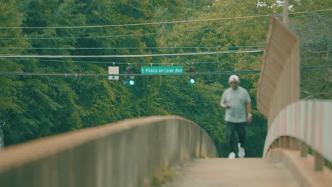 A-Man-Walks-Across-An-Active-Bridge-With-Traffic-While-Texting