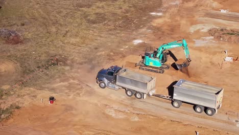 Excavadora-De-Orugas-Cargando-Un-Camión-Y-Un-Remolque-Desde-Un-Montón-De-Tierra