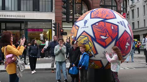 Kids-being-near-the-footabll,-UEFA-Champions-League,-Regents-Street,-London,-United-Kingdom