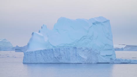 Antártida-Hermoso-Iceberg-Al-Atardecer,-Formación-De-Hielo-Flotando-En-El-Océano,-Enormes-Icebergs-Azules-Grandes-Con-Formas-Asombrosas-En-El-Agua-De-Mar-De-La-Península-Antártica-En-El-Paisaje-Marino-De-Invierno-Al-Amanecer,-Detalle-Del-Iceberg