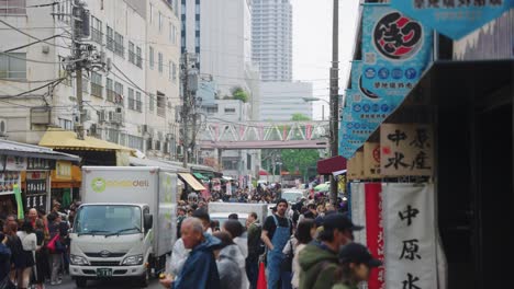 Crowds-of-People-buying-sushi-and-fish-at-Tsukiji-Market-in-Tokyo,-location-of-Tuna-Auctions