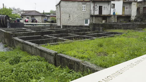 Touristen,-Die-An-Den-Überresten-Einer-Antiken-Wassermühle-In-Der-Burg-Von-Guimaraes-Vorbeikommen