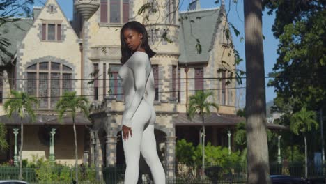 In-a-white-bodysuit,-a-young-girl-revels-in-a-city-day-with-Stollmeyer-castle-in-the-background