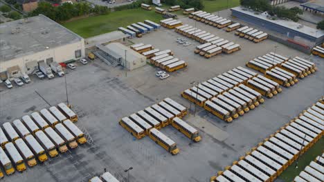 Drone-view-of-row-of-yellow-school-buses-in-large-parking-lot