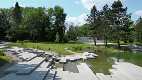 Parque-Verde-Durante-Un-Hermoso-Día-De-Verano-Rodeado-De-Exuberante-Agua,-Vegetación-Y-Césped