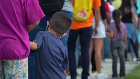 SAN-JOSÉ,-COSTA-RICA---FEBRUARY-6,-2022:-Election-Day-editorial,-a-queue-outside-the-voting-station,-with-people-standing-in-line-and-a-kid-waiting-together-with-her-mother