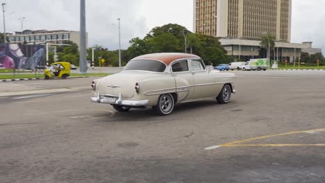 Chevrolet-Bel-Air-1953-Saloon-car-departing-from-Plaza-de-la-Revolucion,-Havana,-Cuba,-panning-shot-with-zoom