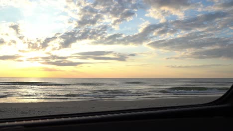 Slider-shot-of-the-sunset-and-sea-view-from-a-car's-trunk