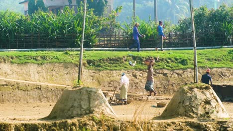 Trabajadores-Con-Hombres-Recogiendo-Tierra-Para-La-Fabricación-De-Ladrillos