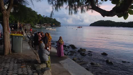 Female-group,-island-residents-congregate-together,-sunrise-beach-scene