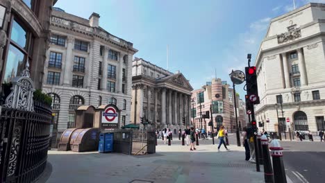 Bank-Station-Entrance-With-Mansion-House-In-The-Background-On-Sunny-Clear-Morning-With-People-Walking-Past