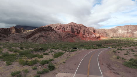 Scenic-road-through-Route-68,-Quebrada-de-las-Conchas-in-Cafayate,-Salta-with-red-rock-formations-and-greenery