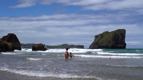 Mutter-Spielt-Mit-Ihren-Kindern-Im-Urlaub-Am-Ballota-Beach-In-Den-Wellen