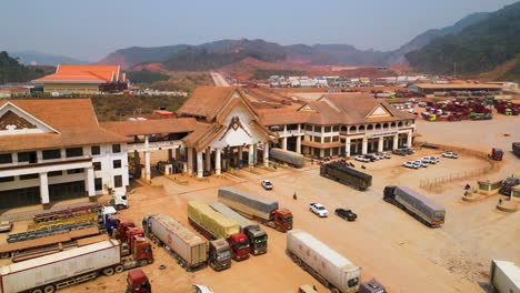 Aerial-of-the-cargo-trucks-and-cars-passing-through-the-customs-checkpoint-at-the-Boten-Special-Economic-Zone,-Laos,-cross-border-trade-and-efficient-customs-procedures-at-a-crucial-economic-junction