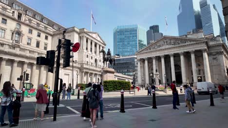 Profile-view-Royal-Exchange,-Bank-of-England-in-London-with-tourists-passing-by