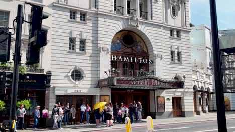 Theatre-Goers-Queuing-Outside-Victoria-Palace-Theatre-On-Sunny-Morning