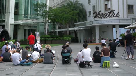 Artists-and-painters-painting-in-public-spaces-outside-the-Capitol-Building,-Singapore