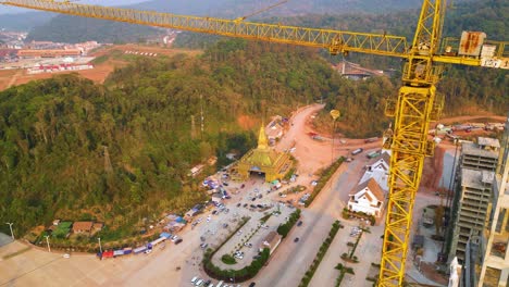 Vista-Aérea-De-Una-Grúa-Y-Un-Sitio-De-Construcción-En-La-Zona-Económica-Especial-De-Boten,-Laos,-Cerca-De-La-Frontera-Con-China,-El-Concepto-De-Rápido-Desarrollo-Urbano-Y-Crecimiento-Económico-En-Una-Región-Transfronteriza.