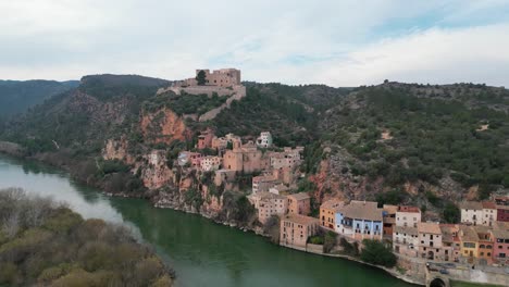 Ciudad-De-Miravet-Junto-Al-Río-Ebro-En-Tarragona,-España-Con-Edificios-Históricos,-Vista-Aérea