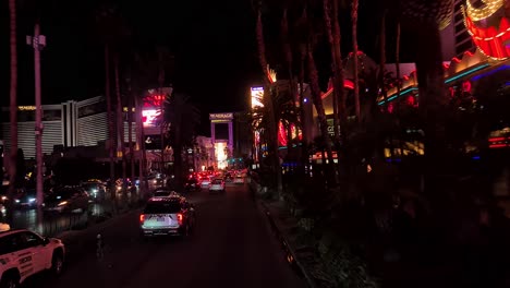 Las-Vegas-USA,-Driving-on-Vegas-Strip-at-Night-by-Flamingo,-Caesar-Palace-and-Mirage-Hotel-Casino-Buildings-in-Lights