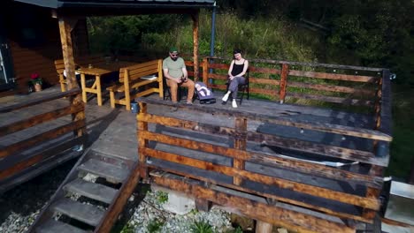 Drone-flying-backwards-capturing-a-family-at-a-beautiful-tiny-house-in-Romania