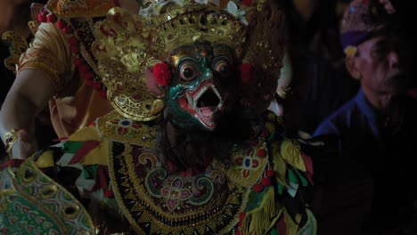 A-close-up-of-a-traditional-Balinese-dancer-adorned-in-an-intricate-costume-and-mask,-performing-in-Ubud,-Bali,-Indonesia