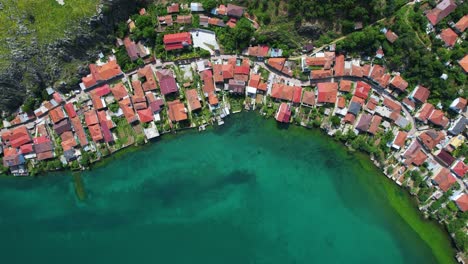 Ruhige-Bucht-Auf-Der-Felsigen-Halbinsel-Lin,-Umspült-Vom-Smaragdgrünen-Wasser-Des-Sees,-Rot-Gedeckte-Fischerhäuser,-Pogradec