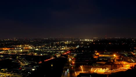 Beleuchtete-Stadt-In-Dunkler-Nacht-Mit-Starkem-Verkehr-Während-Der-Hauptverkehrszeit