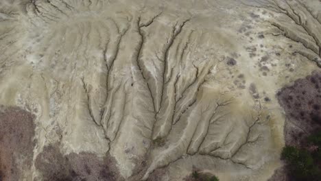 Wonderful-drone-shot,-over-the-dry,-desert-lands-of-a-mud-volcano-with-fissures-in-the-ground