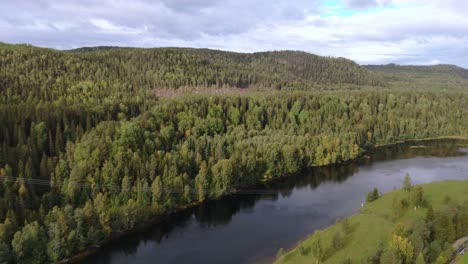 Breathtaking-aerial-drone-footage-of-a-serene-river-in-Northern-Sweden,-surrounded-by-vibrant-autumn-forests