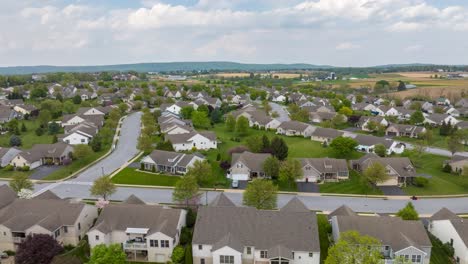 Weitläufiges-Vorstadtviertel-Mit-üppigen-Grünen-Rasenflächen-Und-Verwinkelten-Straßen,-Umgeben-Von-Offenen-Feldern