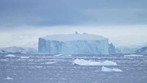 Grandes-Icebergs-De-La-Antártida,-Paisajes-Invernales,-Formas-Sorprendentes,-Formaciones-De-Hielo-De-Enormes-Icebergs-Azules-Enormes-En-Un-Hermoso-Paisaje-Marino-De-La-Península-Antártica-Con-Agua-De-Mar.