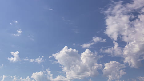 Blue-sky-and-white-fluffy-clouds-flowing,-time-lapse-view