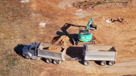 Loading-buckets-of-dirt-into-a-truck-and-trailer-from-an-excavator