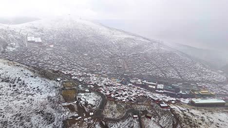 Buddhist-academy-in-the-mountains-of-Sichuan-Sertar-County,-Larung-Gar,-Buddhism-center-in-snow
