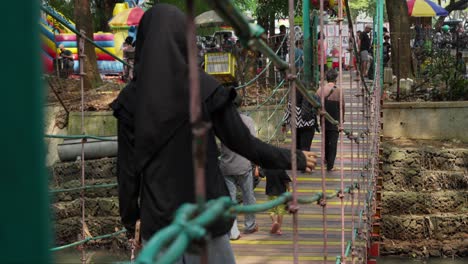 Gente-Caminando-Sobre-El-Puente-Colgante-En-Taman-Kota-1-BSD-Park-En-South-Tangerang,-Indonesia