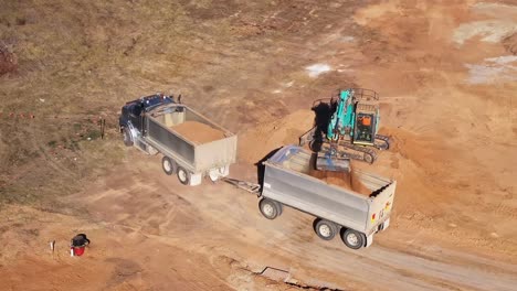 Aerial-of-excavator-loading-the-rear-trailer-of-a-truck-and-trailer