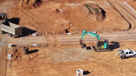 Tracked-excavator-moving-towards-a-truck-and-trailer-for-loading