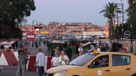 People-visiting-Jemaa-el-Fnaa-square-at-sunset,-Marrakesh-Medina-Quarter