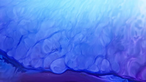 Tinta-Azul-Y-Violeta-Vibrante-Girando-Y-Mezclándose-En-Agua-Creando-Patrones-Fluidos-Abstractos