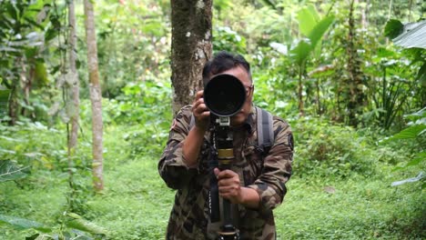 Naturfotograf-Mit-Teleobjektiv-Und-Tarnkleidung-Fotografiert-Wildtiere-Mit-Stativ